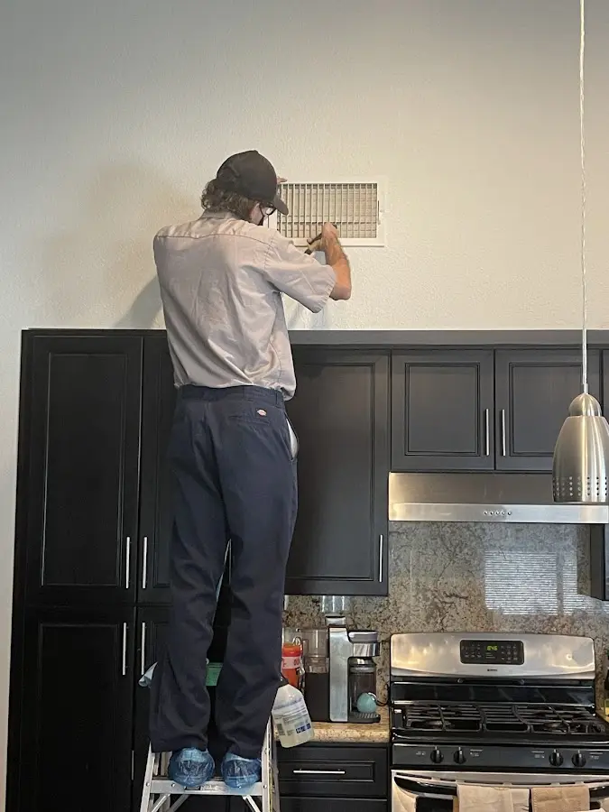 Technician inspecting an air vent during HVAC service in Oceanport